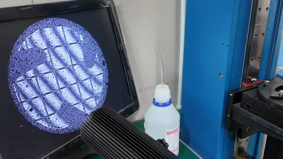 Magnified inspection of a coated-glass sample at an optical inspection station