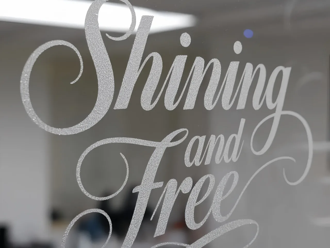 Decorative glass lettering with a textured surface effect.