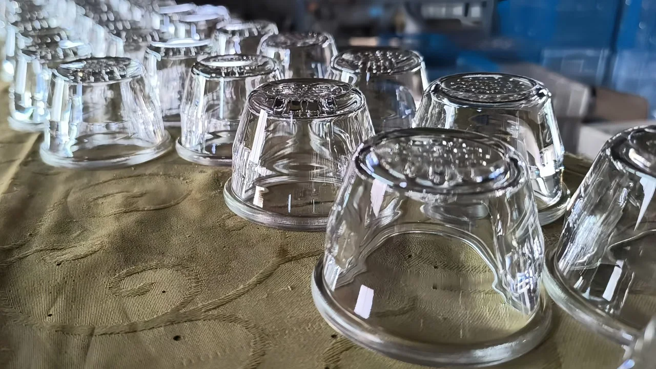 Clear hollow pressed-glass covers arranged on a workshop surface