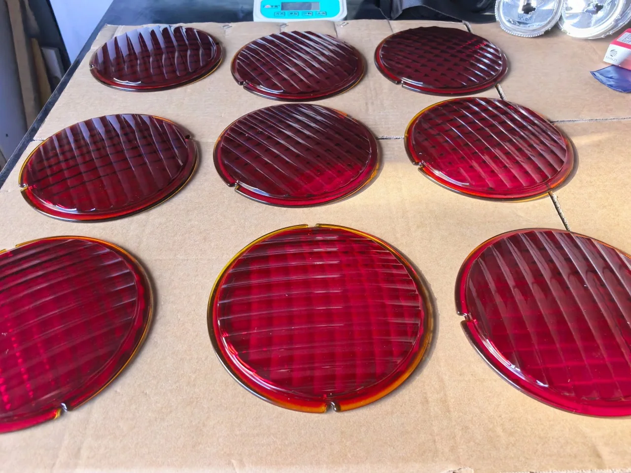 Red ribbed pressed-glass discs laid out on a workshop bench
