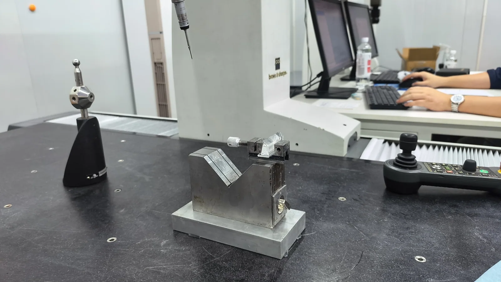 A measurement fixture and reference sphere on a coordinate measuring machine table