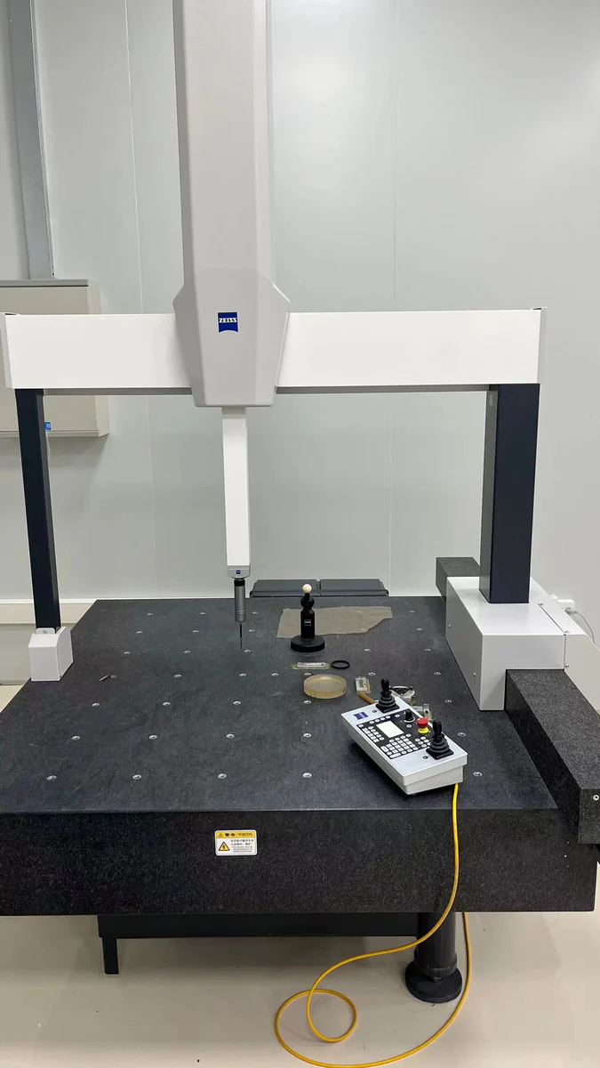 A coordinate measuring machine with a probe and reference sphere above its measurement table