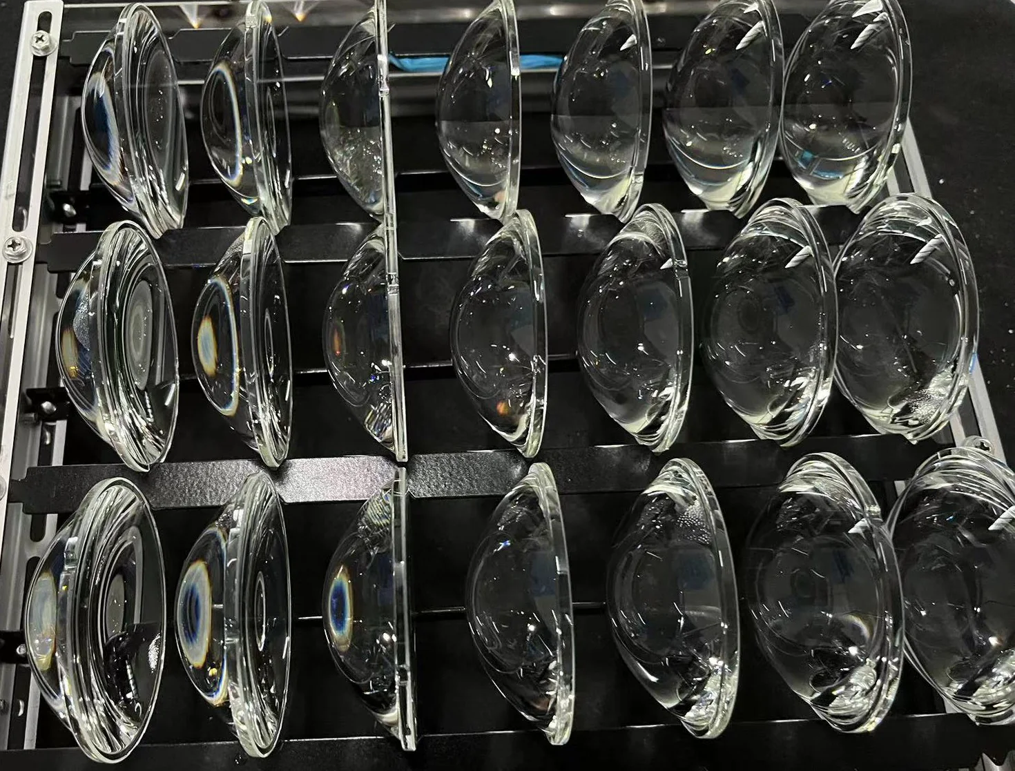 Finished clear glass lenses arranged in a production rack