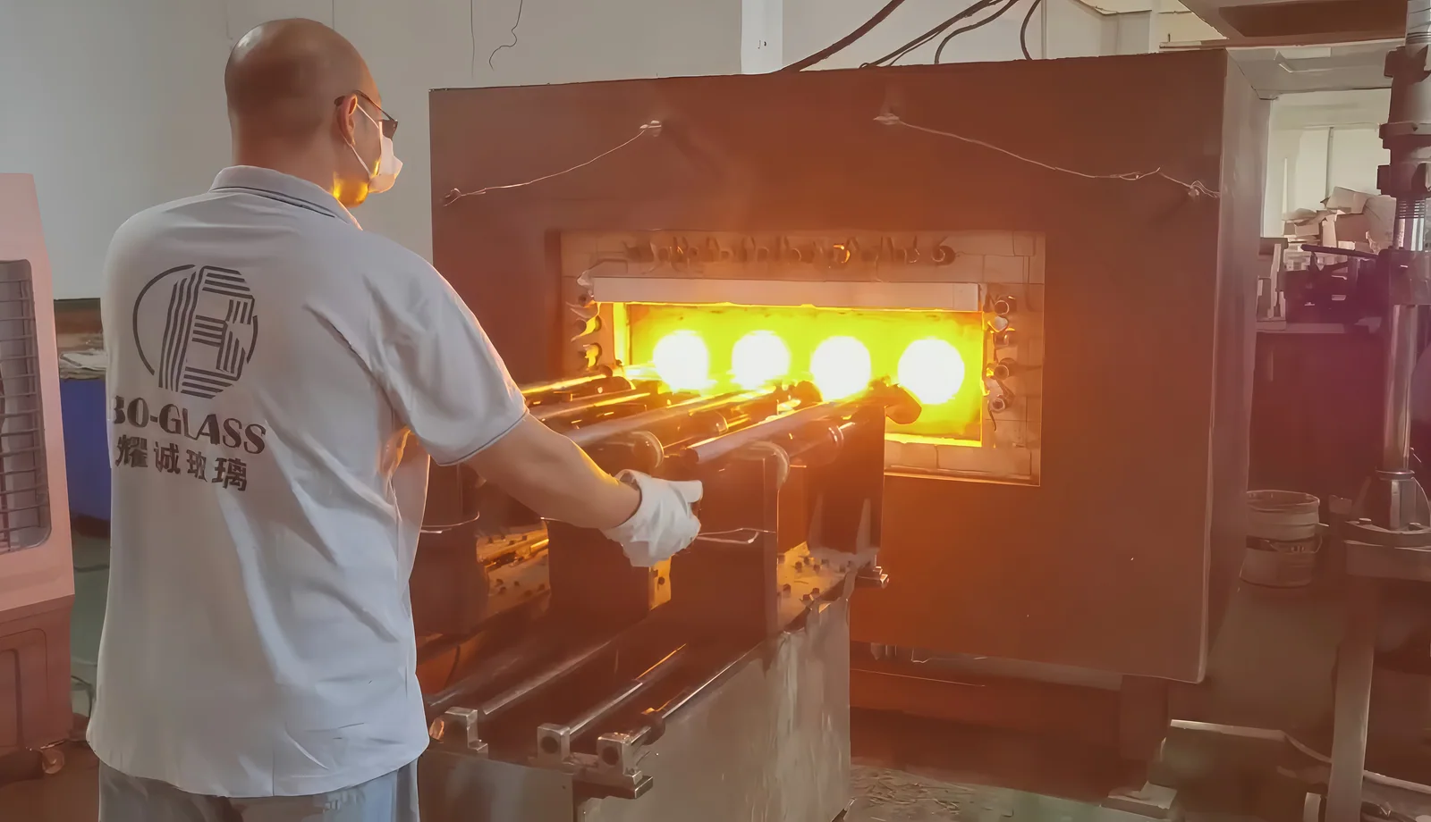 Operator handling glass at an illuminated heating workstation