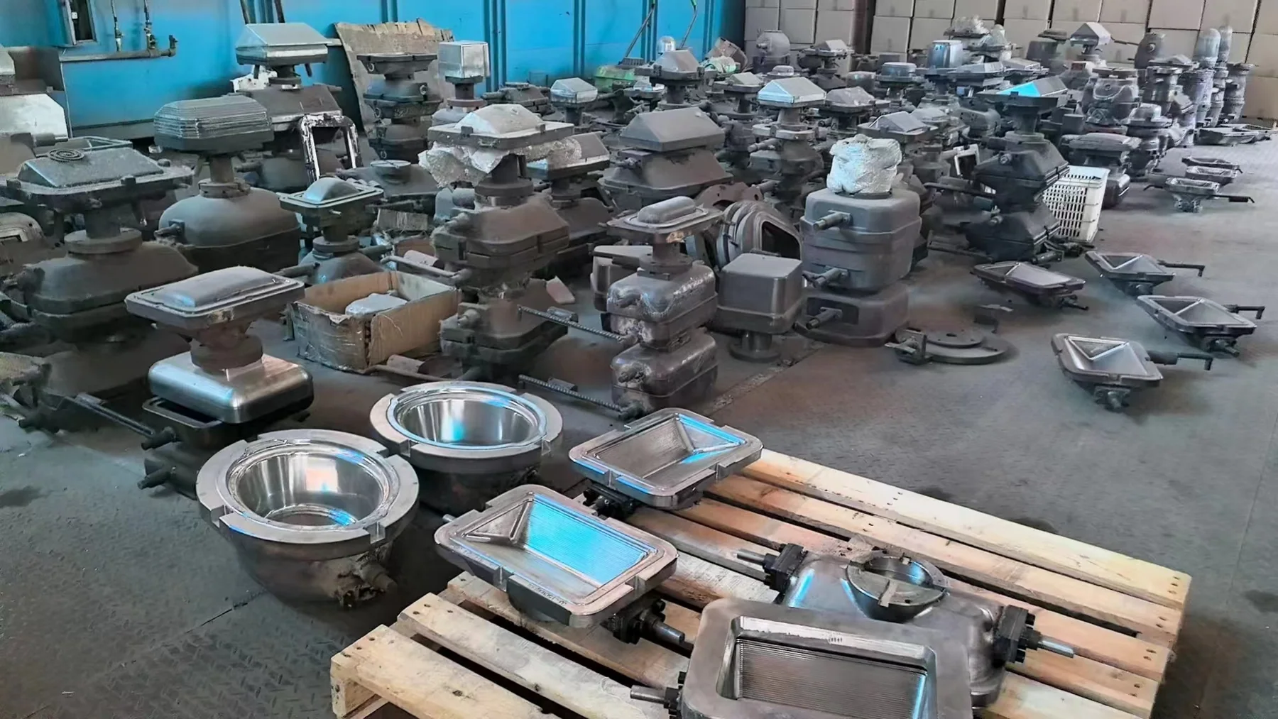 Round and rectangular glass pressing mould assemblies arranged in a workshop
