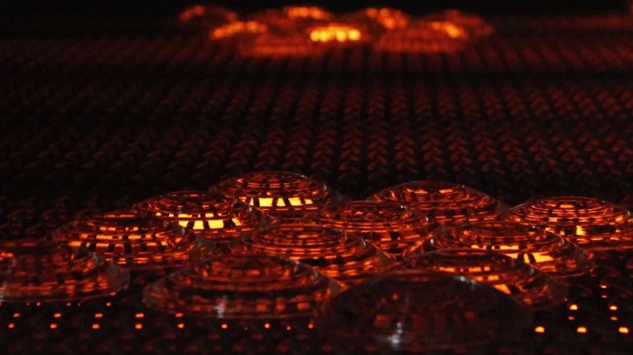 Hot concentric-ribbed pressed-glass articles on a mesh conveyor