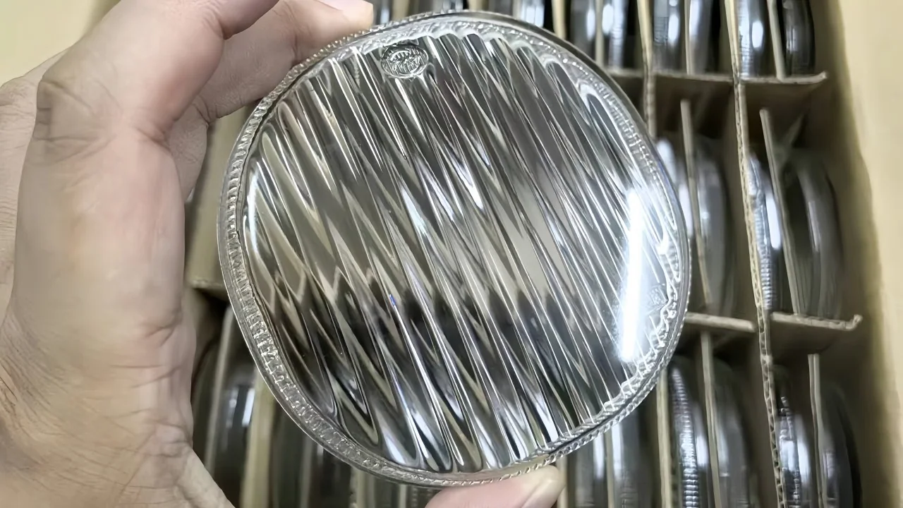 A clear ribbed pressed-glass disc held in front of racks of matching components