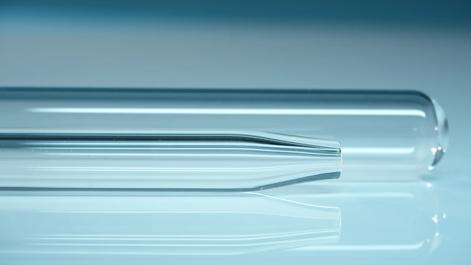 Prepared clear glass tubes showing a tapered neck with a small opening and a rounded closed end.