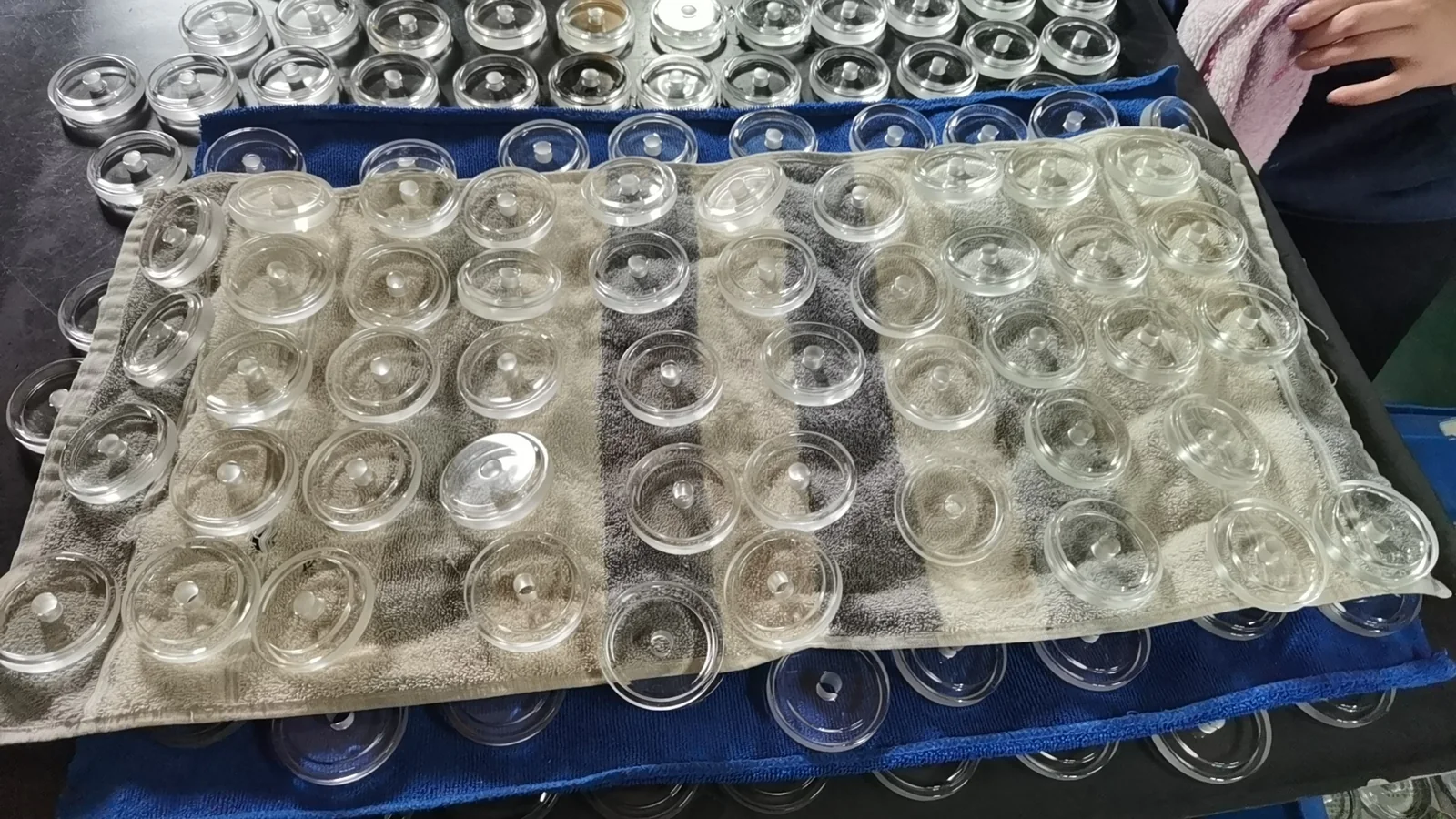 Batch of circular pressed glass lens components during production handling