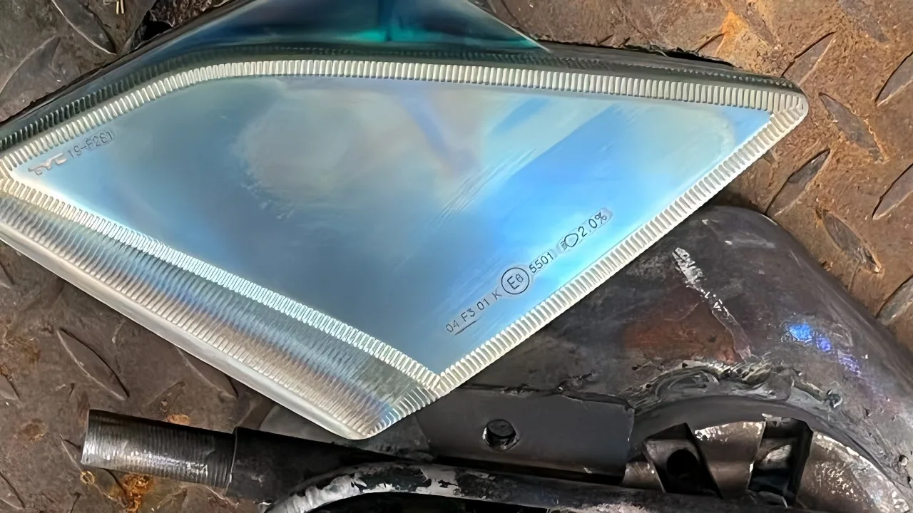 Close view of an asymmetric pressed-glass cover with a textured perimeter and projecting rim