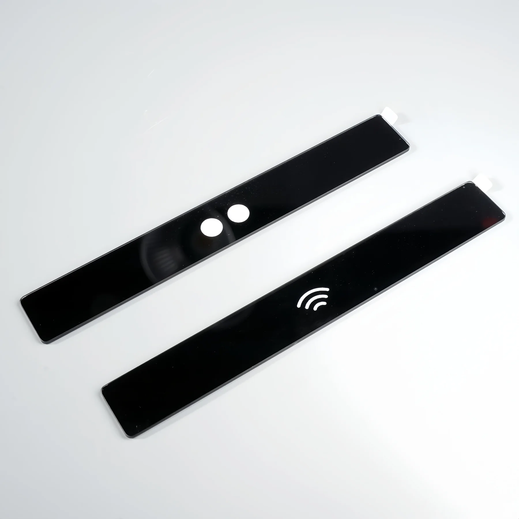 Real black printed sensor strips with transparent apertures for transmission, edge and pinhole inspection.