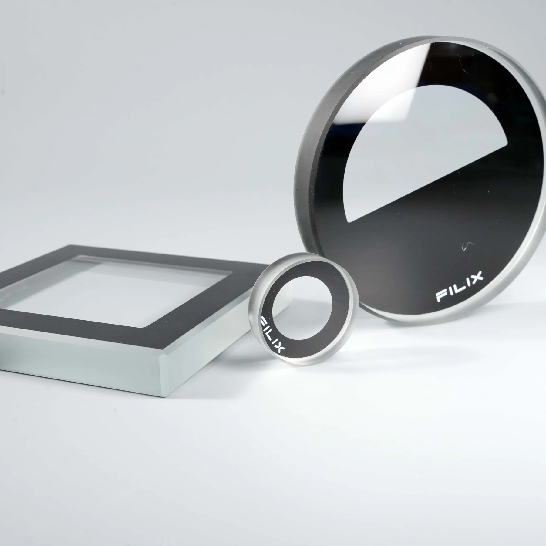 Real round and rectangular cover-glass parts with opaque black perimeter printing.