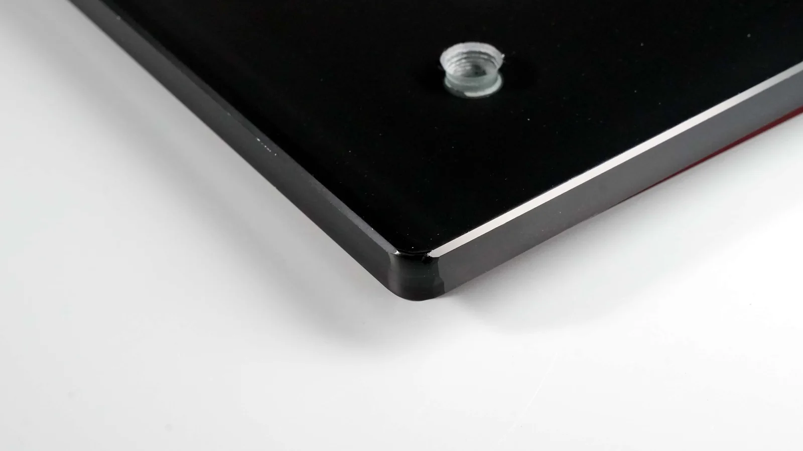 Real black printed glass panel detail with a machined opening and threaded insert.